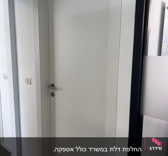 דלת לבנה עם ידית כסופה במסגרת לבנה
